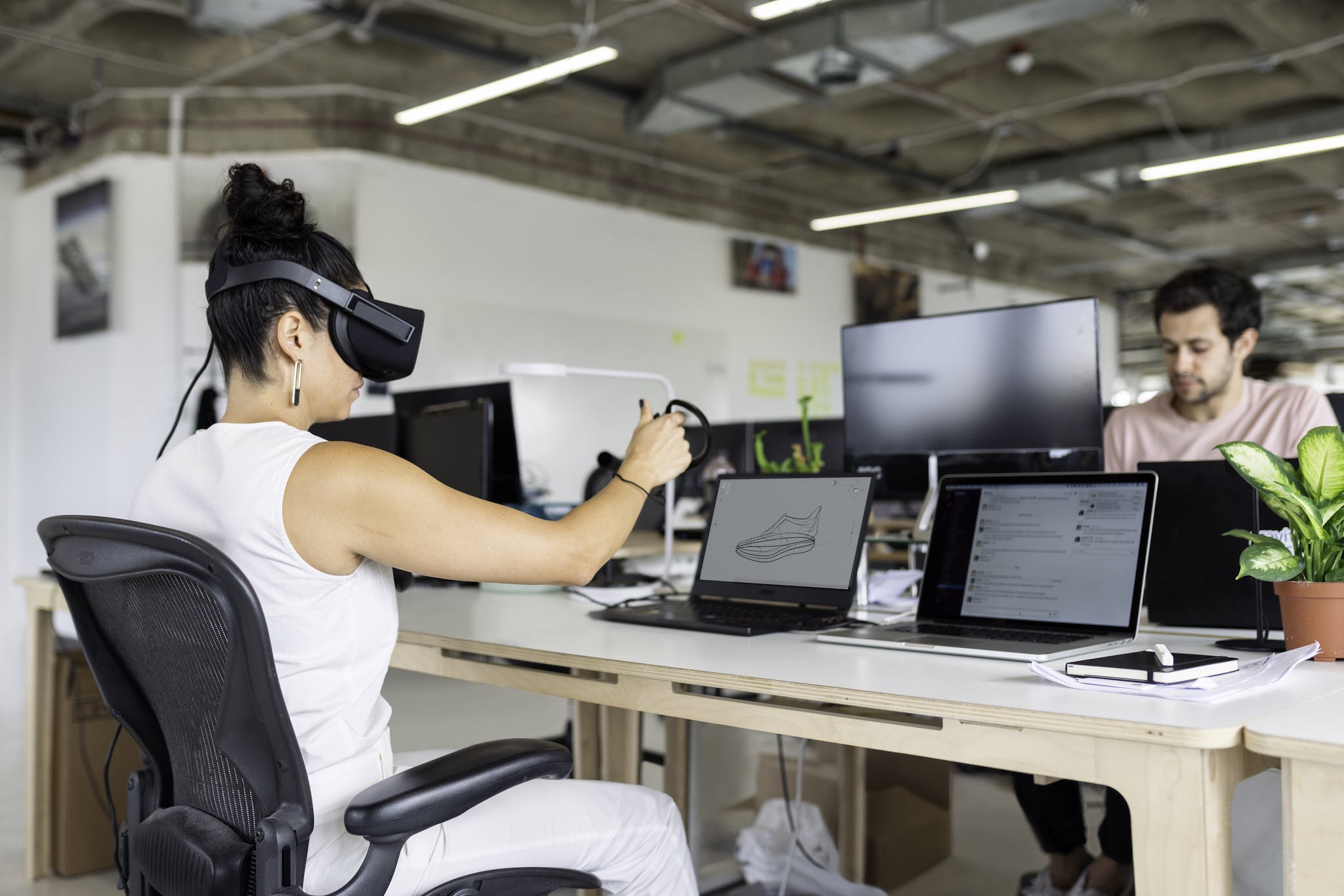 Woman Using Laptop Computer With VR Headset